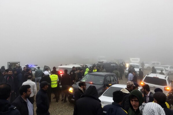 In this photo provided by Moj News Agency, rescue teams and people are seen near the site of the incident of the helicopter carrying Iranian President Ebrahim Raisi in Varzaghan in northwestern Iran, Sunday, May 19, 2024. A helicopter carrying President Raisi, the country's foreign minister and other officials apparently crashed in the mountainous northwest reaches of Iran on Sunday, sparking a massive rescue operation in a fog-shrouded forest as the public was urged to pray. (Azin Haghighi/Moj News Agency via AP)