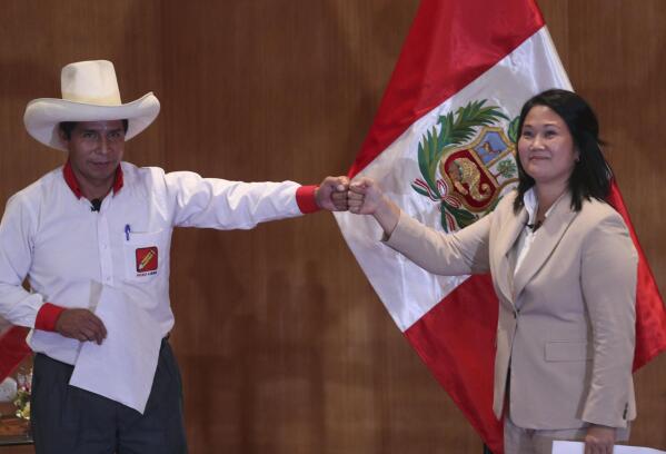 Free Peru party presidential candidate Pedro Castillo, left, bumps fists with rival candidate Keiko Fujimori, of the Popular Force party, at the Peru Medical School in Lima, Peru, Monday, May 17, 2021. The candidates took an oath coined the “Citizens Proclamation” that commits the winner of the June presidential election to defend democracy, to fight COVID-19, to defend the right to life, to guarantee human rights and freedom of the press, as well as to leave the presidency after five years and not seek reelection. (AP Photo/Martin Mejia)
