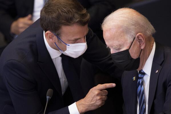 FILE - In this June 14, 2021 file photo, U.S. President Joe Biden, right, speaks with French President Emmanuel Macron during a plenary session during a NATO summit at NATO headquarters in Brussels. French President Emmanuel Macron expects "clarifications and clear commitments" from President Joe Biden in a call to be held later on Wednesday to address the submarines' dispute, Macron's office said. (Brendan Smialowski, Pool via AP, File)