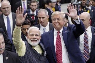 FILE - India Prime Minister Narendra Modi and then President Donald Trump walk the perimeter of the arena floor to greet attendants after Modi's speech during the "Howdi Modi" event, September 22, 2019, at NRG Stadium in Houston. Trump says he’s meeting next week with Indian Prime Minister Narendra Modi. Modi is scheduled to be in the United States this weekend hosted by President Joe Biden in his Wilmington, Delaware hometown along with leaders of Australia and Japan for a summit of the so-called Quad. (AP Photo/Michael Wyke, File)