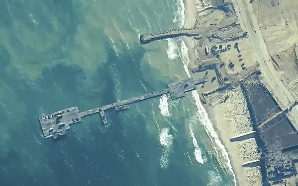 FILE - The image provided by U.S, Central Command, shows U.S. Army soldiers assigned to the 7th Transportation Brigade (Expeditionary), U.S. Navy sailors assigned to Amphibious Construction Battalion 1, and Israel Defense Forces placing the Trident Pier on the coast of Gaza Strip on May 16, 2024. A key section of the U.S. military-built pier designed to carry badly needed aid into Gaza by boat has been reconnected to the Gaza beach following storm damage repairs and aid will begin to flow soon, the U.S. Central Command announced Friday. (U.S. Central Command via AP)