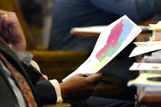 Sen. Joseph Thomas, D-Yazoo City, holds a copy of the proposed congressional redistricting map as debate over a different version is held in the Chamber at the Mississippi State Capitol in Jackson, Miss., Wednesday, Jan. 12, 2022. (AP Photo/Rogelio V. Solis)