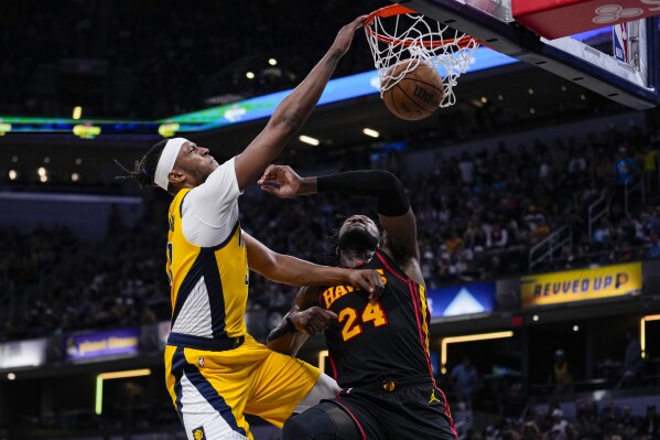 Indiana Pacers center Myles Turner (33) shoots over Atlanta Hawks forward Bruno Fernando (24) during the second half of an NBA basketball game in Indianapolis, Sunday, April 14, 2024. (AP Photo/Michael Conroy)