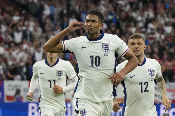 England's Jude Bellingham, front, celebrates with teammates after scoring the opening goal during a Group C match between Serbia and England at the Euro 2024 soccer tournament in Gelsenkirchen, Germany, Sunday, June 16, 2024. (AP Photo/Martin Meissner)