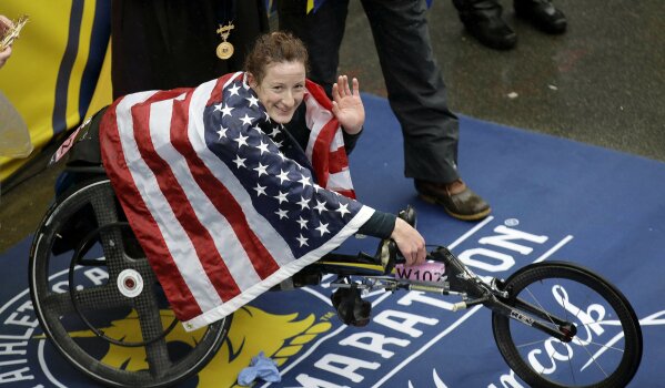 FILE - In this April 16, 2018, file photo, Tatyana McFadden, of the United States, celebrates after winning the women's wheelchair division of the 122nd Boston Marathon, in Boston. McFadden is among several Paralympic athletes who are profiled in the Nexflix documentary “Rising Phoenix” that will be released in 190 countries on Wednesday, Aug. 26, 2020.(AP Photo/Charles Krupa, File)