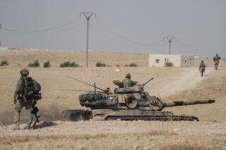 FILE - Turkish tanks and troops are deployed near the Syrian town of Manbij, Syria, Oct. 15, 2019. Hardly a day passes in northern Syria without Kurdish fighters and opposition gunmen backed by Turkey exchanging gunfire and shelling and concerns are rising that the situation will only get worse in the coming weeks with Ankara threatening to launch a new major operation along its southern border. (Ugur Can/DHA via AP, File)