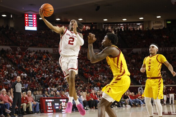 Oklahoma guard Javian McCollum (2) prepares to shoot next to Iowa State forward Hason Ward, center, as Iowa State guard Tamin Lipsey (3) watches during the second half of an NCAA college basketball game, Saturday, Jan. 6, 2024, in Norman, Okla. (AP Photo/Nate Billings)