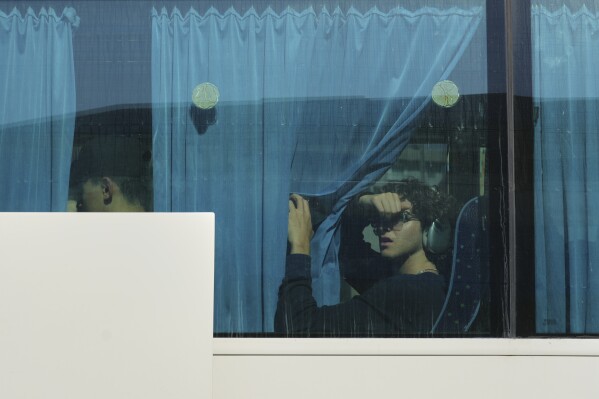 An evacuee from Israel is seen in a bus after arriving at a port with a ship in Larnaca, Cyprus, Wednesday, June 18, 2025. (AP Photo/Petros Karadjias)