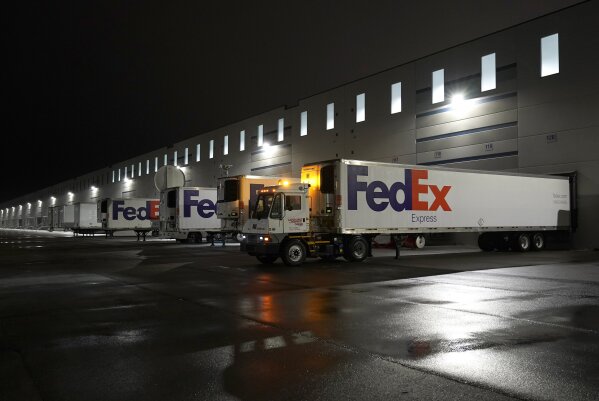 FILE - In this Dec. 20, 2020, file photo, FedEx trucks are parked at the loading dock outside the...