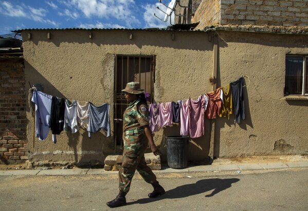 South African National Defence Forces, walks on the street of a densely populated Alexandra township in Johannesburg, South Africa, Thursday, April 16, 2020. South African President Cyril Ramaphosa extended the lockdown by an extra two weeks in a continuing effort to contain the spread of COVID-19 coronavirus. (AP Photo/Themba Hadebe)
