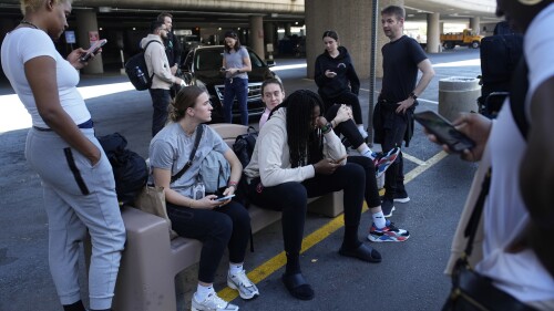 Pemain dan staf tim bola basket New York Liberty WNBA menunggu untuk menaiki bus di Bandara Internasional Harry Reid, Rabu, 28 Juni 2023, di Las Vegas.  New York Liberty memiliki 13 jam perjalanan sehari dari Connecticut ke Las Vegas selama perjalanan darat tiga pertandingan baru-baru ini, yang membutuhkan dua kali naik bus, dua penerbangan komersial, dan beberapa jam di tiga bandara.  (Foto AP/John Locher)