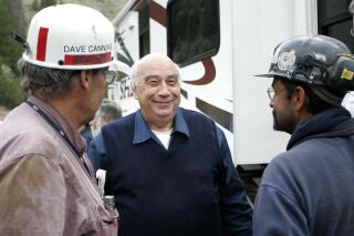 Robert Murray, center, chief executive of Murray Energy Corp., smiles while talking to Dave Canning, left, and Mike Glassom, right, two miners in charge of drilling bore holes into the Crandall Canyon Mine, before a news conference northwest of Huntington Utah, Sunday, Aug, 26, 2007. Murray, the founder and former president and CEO of a major U.S. coal operator that recently emerged from federal bankruptcy, has retired as chairman of the company's board. Murray ended a six-decade career by announcing his retirement Monday, Oct. 19, 2020 as board chairman of American Consolidated Natural Resource Holdings Inc. (AP Photo/Kenny Crookston)