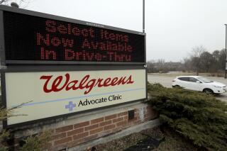 FILE - In this March 27, 2020, file photo, a Walgreens sign is displayed outside the store in Wheeling, Ill. Walgreens will hike starting pay to $15 an hour beginning in October, as employers across the United States continue boosting wages to attract workers. The drugstore chain said Tuesday, Aug. 31, 202, that the wage hike will take effect in phases and be completed by November 2022. (AP Photo/Nam Y. Huh, File)