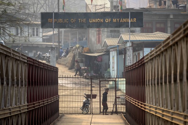 FILE- A Myanmarese looks towards the Indian side at the India-Myanmar border in Mizoram, India, Saturday, March 20, 2021. More than half of the estimated 5,000 refugees who had fled the heavy fighting in Myanmar’s western Chin state and had entered India’s northeastern Mizoram state have begun returning home, Indian officials said Thursday, Nov. 16, 2023. (AP Photo/Anupam Nath, File)