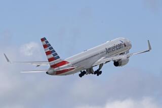 In this June 3, 2016 file photo, an American Airlines passenger jet takes off from Miami International Airport in Miami. American Airlines says a passenger entered the open cockpit of a jet that was preparing to take off in Honduras, and he damaged the plane before crew members and police could stop him. American said Wednesday, Jan. 12, 2022 that the man was arrested. The flight, which was bound for Miami, was delayed several hours until American could fly a replacement plane into Honduras. (AP Photo/Alan Diaz)