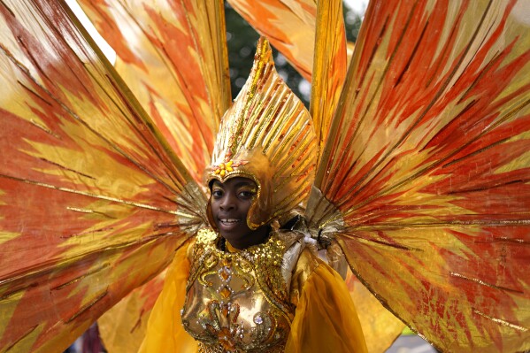A participant in colourful costume on the first day of the Notting Hill Carnival, which is traditional known as Children's Day, in London, Sunday, Aug. 27, 2023. (AP Photo/Alberto Pezzali)