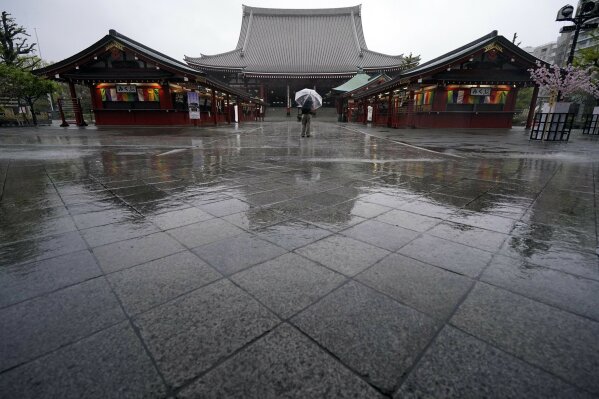 A man stands at Sensoji Temple in the empty Asakusa district Monday, April 13, 2020, in Tokyo. Japanese Prime Minister Shinzo Abe declared a state of emergency last week for Tokyo and some other prefectures to ramp up defenses against the spread of the coronavirus. (AP Photo/Eugene Hoshiko)
