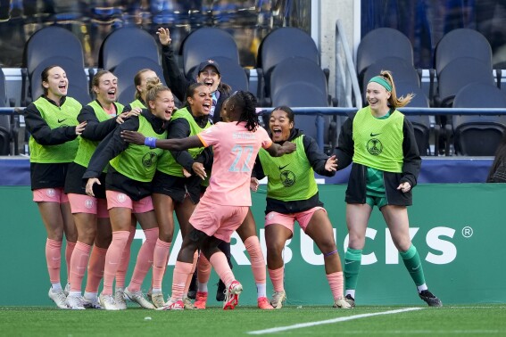 Orlando Pride forward Barbra Banda (22) celebrates her goal against the Seattle Reign with teammates on the bench during the second half of an NWSL soccer match, Sunday, May 19, 2024, in Seattle. Orlando won 3-2. (AP Photo/Lindsey Wasson)