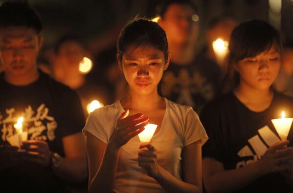 FILE - In this June 4, 2015 file photo, people attend a candlelight vigil at Victoria Park in Hong Kong. The group, Hong Kong Alliance in Support of Patriotic Democratic Movements of China, that had organized annual vigils in remembrance of victims of the Chinese military’s crushing of the 1989 Tiananmen Square pro-democracy protests voted to disband Saturday, Sept. 25, 2021 amid an ongoing crackdown on independent political activism in the semi-autonomous Chinese city. (AP Photo/Vincent Yu, File)