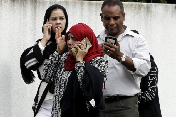 
              FILE - In this March 15, 2019, file photo, people wait outside a mosque in central Christchurch, New Zealand. The gunman who attacked two mosques in New Zealand, killing at least 49 people, was said to have been inspired by the man who in 2015 killed nine black worshippers at a church in Charleston, South Carolina. (AP Photo/Mark Baker, File)
            