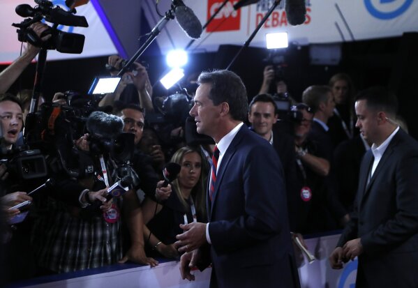 FILE - In this Tuesday, July 30, 2019, file photo, Montana Gov. Steve Bullock talks to reporters after the first of two Democratic presidential primary debates hosted by CNN in the Fox Theatre in Detroit. Bullock announced Monday, Dec. 2, 2019, that he is ending his Democratic presidential campaign. (AP Photo/Carlos Osorio, File)