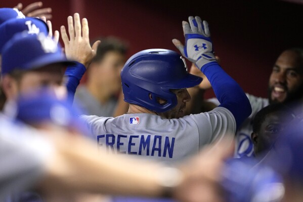 Los Angeles Dodgers' Freddie Freeman celebrates scoring on a sacrifice fly hit by Max Muncy during the fifth inning of a baseball game against the Arizona Diamondbacks, Tuesday, Aug. 8, 2023, in Phoenix. (AP Photo/Matt York)