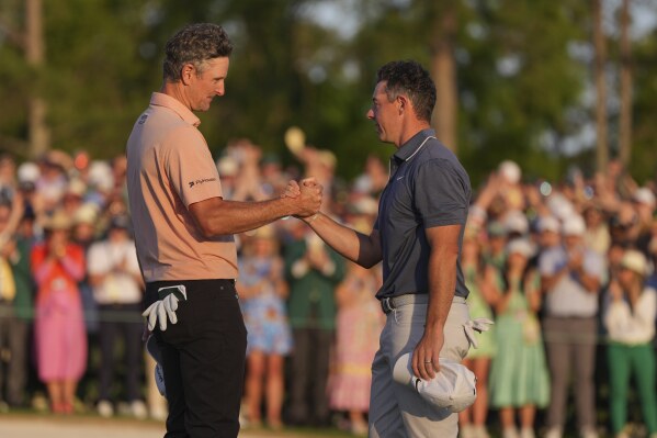 Rori McClray, da Irlanda do Norte, parabeniza Justin Rose da Inglaterra, após a rodada final do torneio de golfe Masters, Augusta, Augusta, KA.
