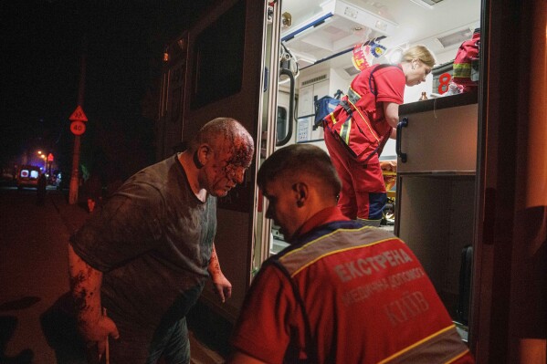 Paramedics treat an injured man near a house destroyed by a Russian airstrike in a residential neighborhood in Kyiv, Ukraine, on Thursday, April 24, 2025. (AP Photo/Evgeniy Maloletka)