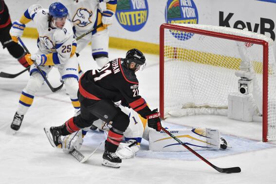 Carolina Hurricanes center Derek Stepan (21) moves the puck around Buffalo Sabres goalie Ukko-Pekka Luukkonen before scoring during the third period of an NHL hockey game in Buffalo, N.Y., Wednesday, Feb. 1, 2023. (AP Photo/Adrian Kraus)