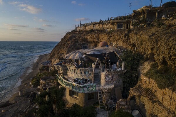 Nissim Kahlon's home, chiseled out of the sandstone cliffs, overlooks the Mediterranean sea in Herzliya, Israel, Wednesday, June 28, 2023. Over half a century, Kahlon has transformed a tiny cave on a Mediterranean beach into an elaborate underground labyrinth filled with chiseled tunnels, detailed mosaic floors and a network of staircases and mysterious chambers. Fifty years after Kahlon moved into the home, Israel's Environmental Protection Agency has served him an eviction notice, claiming the structure threatens Israel's coastline. (AP Photo/Ariel Schalit)