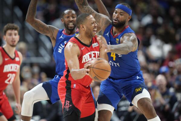 Houston Rockets guard Eric Gordon, center, passes the ball under pressure from Denver Nuggets guard Davon Reed, left, and center DeMarcus Cousins in the second half of an NBA basketball game Friday, March 4, 2022, in Denver. The Nuggets won 116-101. (AP Photo/David Zalubowski)