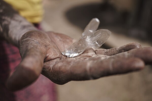 Sadio Camara, a gold processor, holds up a bag of mercury at her home in the Kedougou region of Senegal on Thursday, Jan. 16, 2025. (AP Photo/Annika Hammerschlag)