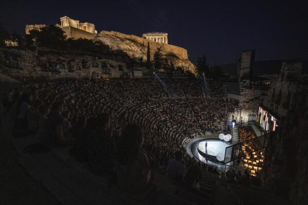 Spectators watch a performance of "Madame Butterfly" at the Odeon of Herodes Atticus in Athens, as on the background is seen the ancient temples of goddess Nike, left, and the Parthenon on Thursday, June 1, 2023. The annual arts festival in Athens and at the ancient theater of Epidaurus in southern Greece is dedicated this year to the late opera great Maria Callas who was born 100 years ago. (AP Photo/Petros Giannakouris)