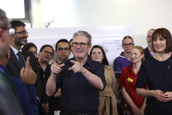 Britain's Prime Minister Keir Starmer and Chancellor Rachel Reeves speak with members of staff, during a visit to University Hospital Coventry and Warwickshire, in Coventry, England, Thursday, Oct. 31, 2024. (AP Photo/Darren Staples, pool)
