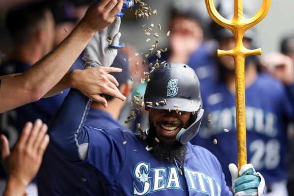 Seattle Mariners' Teoscar Hernandez has seeds poured on him by teammates as they celebrate his three-run home run against the Oakland Athletics during the third inning of a baseball game Wednesday, Aug. 30, 2023, in Seattle. (AP Photo/Lindsey Wasson)