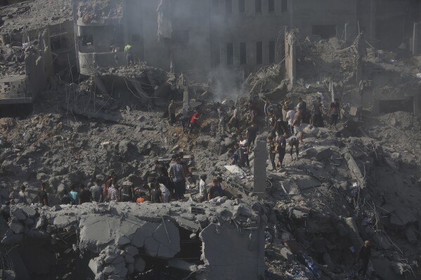 Người Palestine tìm kiếm những người sống sót trong đống đổ nát của một tòa nhà bị phá hủy sau cuộc không kích của Israel vào trại tị nạn Bureij, Dải Gaza, Thứ Năm, ngày 2 tháng 11 năm 2023. (Ảnh AP / Mohammed Dahman)