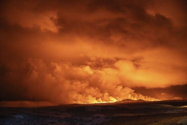 The night sky is illuminated caused by the eruption of a volcano in Grindavik on Iceland's Reykjanes Peninsula, Monday, Dec. 18, 2023. (AP Photo/Marco Di Marco)