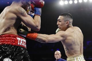 FILE - In this April 20, 2019, file photo, Teofimo Lopez, right, punches Finland's Edis Tatli during the first round of a boxing bout in New York. Lopez is symptomatic after testing positive for COVID-19, and his bout with mandatory challenger George Kambosos has been postponed until Aug. 14. Lopez and Kambosos were scheduled to fight Saturday night at the Miami Marlins' home stadium. (AP Photo/Frank Franklin II, File)