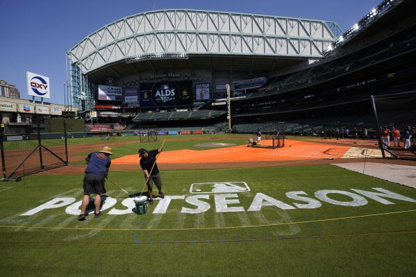 Sixto Zapata, right, and Mike Lidecker paint the field at Minute Maid Park ahead of Game 1 of baseball's American League Division Series, Monday, Oct. 10, 2022, in Houston. The Houston Astros will play the Seattle Mariners Tuesday. (AP Photo/David J. Phillip)