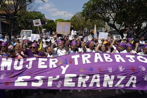 People carry a banner that reads in Spanish 