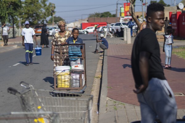 Inwoners van de stad Soweto, Zuid-Afrika, staan ​​in de rij voor water op zaterdag 16 maart 2024. Duizenden Zuid-Afrikanen staan ​​in de rij voor water terwijl Johannesburg, de grootste stad van het land, wordt geconfronteerd met een ongekende ineenstorting van het watersysteem dat miljoenen mensen treft. .  De bevolking, rijk en arm, heeft nog nooit zo’n ernstig tekort gezien.  (AP Foto/Jerome vertraging)