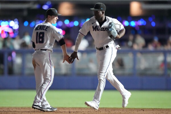 Miami Marlins shortstop Joey Wendle (18) and right fielder Jesus Sanchez congratulate each other after the Marlins beat the Los Angeles Dodgers 11-4 in a baseball game, Wednesday, Sept. 6, 2023, in Miami. (AP Photo/Wilfredo Lee)