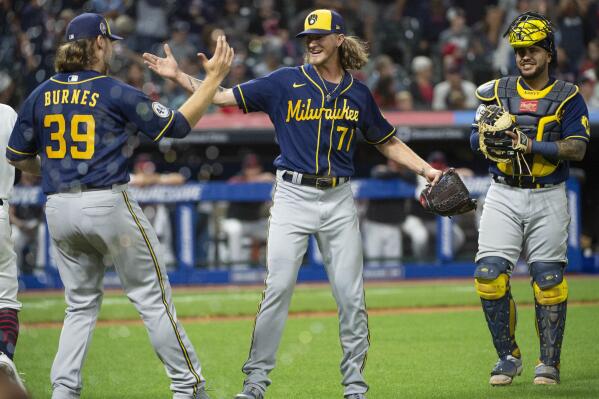 Milwaukee Brewers starting pitcher Corbin Burnes (39) greets relief pitcher Josh Hader as Omar Narvaez watches at the end of a baseball game against the Cleveland Indians in Cleveland, Saturday, Sept. 11, 2021. Hader and Burnes combined for a no-hitter. (AP Photo/Phil Long)