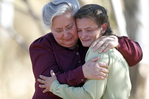 In this Wednesday, Oct. 25, 2017 photo, Norma Richter, left, and Lori Barlow hug after an eviction notice was served on their Fundamentalist Church of Jesus Christ of Latter-Day Saints church meeting house in their community on the Utah-Arizona border. Authorities later canceled the eviction after working out a deal with church leaders. (AP Photo/Rick Bowmer)