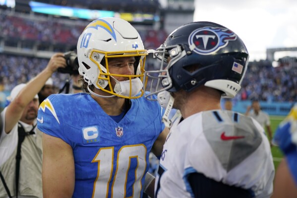 Los Angeles Chargers quarterback Justin Herbert (10) shakes hands with Tennessee Titans quarterback Ryan Tannehill after an NFL football game Sunday, Sept. 17, 2023, in Nashville, Tenn. (AP Photo/George Walker IV)