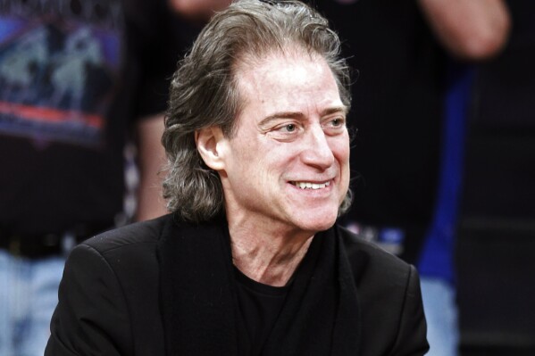 FILE - Comedian Richard Lewis attends an NBA basketball game in Los Angeles on Dec. 25, 2012. Lewis, an acclaimed comedian known for exploring his neuroses in frantic, stream-of-consciousness diatribes while dressed in all-black, leading to his nickname “The Prince of Pain,” has died. He was 76. He died at his home in Los Angeles on Tuesday night after suffering a heart attack, according to his publicist Jeff Abraham. (AP Photo/Alex Gallardo, File)