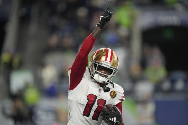 San Francisco 49ers wide receiver Brandon Aiyuk runs back to the sideline after a 28-yard reception for a touchdown during the second half of an NFL football game against the Seattle Seahawks, Thursday, Nov. 23, 2023, in Seattle. (AP Photo/Stephen Brashear)