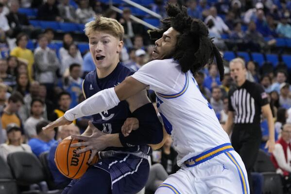 UC Davis guard Leo DeBruhl, left, is defended by UCLA guard Tyger Campbell during the first half of an NCAA college basketball game in Los Angeles, Wednesday, Dec. 21, 2022. (AP Photo/Jae C. Hong)