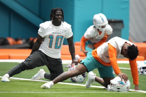 Miami Dolphins wide receiver Tyreek Hill (10) stretches during practice at the NFL football team's training facility, Tuesday, June 6, 2023, in Miami Gardens, Fla. (AP Photo/Lynne Sladky)
