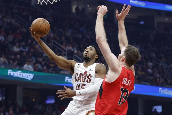 Cleveland Cavaliers guard Donovan Mitchell (45) shoots against Toronto Raptors center Jakob Poeltl (19) during the first half of an NBA basketball game, Sunday, Feb. 26, 2023, in Cleveland. (AP Photo/Ron Schwane)